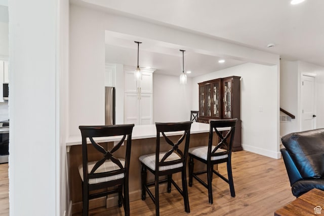1537 N Sweetwater Ln, Farmington, UT 84025 - bar area featuring recessed lighting, light wood finished floors, decorative light fixtures, and stainless steel range oven