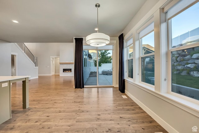 2508 E Lone Hill Dr, Draper Ut Cnty, UT 84020 - unfurnished dining area featuring healthy amount of natural light, light wood finished floors, recessed lighting, and a lit fireplace