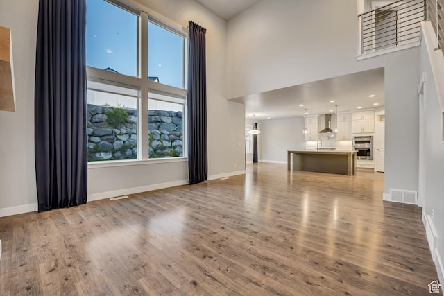 2508 E Lone Hill Dr, Draper Ut Cnty, UT 84020 - unfurnished living room with a towering ceiling and wood finished floors