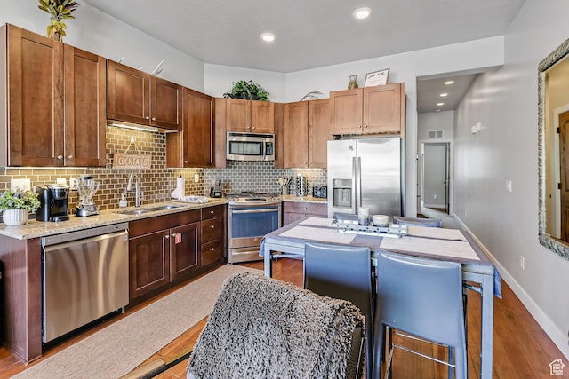 6169 E Park Ln S Unit 30, Park City, UT 84098 - kitchen with stainless steel appliances, backsplash, wood finished floors, light stone countertops, and recessed lighting