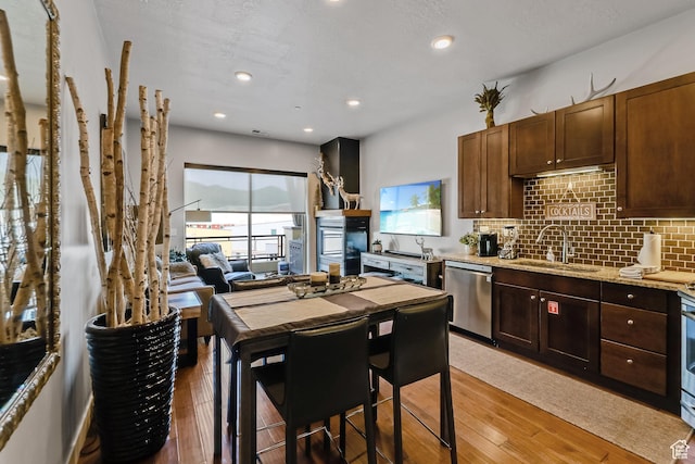 6169 E Park Ln S Unit 30, Park City, UT 84098 - kitchen with stainless steel dishwasher, light wood-style floors, tasteful backsplash, light stone countertops, and recessed lighting