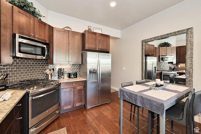 6169 E Park Ln S Unit 30, Park City, UT 84098 - kitchen with appliances with stainless steel finishes, dark wood-style flooring, tasteful backsplash, light stone countertops, and recessed lighting