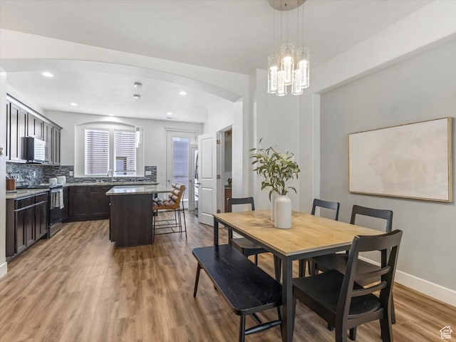 4851 W Daybreak Pkwy, South Jordan, UT 84009 - dining room featuring light wood finished floors, arched walkways, recessed lighting, and a chandelier