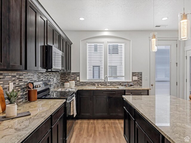 4851 W Daybreak Pkwy, South Jordan, UT 84009 - kitchen with stainless steel range with electric stovetop, light wood finished floors, tasteful backsplash, decorative light fixtures, and light stone countertops