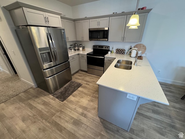949 W Big Ben Ln Unit I304, Saratoga Springs, UT 84045 - kitchen with appliances with stainless steel finishes, a peninsula, gray cabinetry, light wood-type flooring, and pendant lighting