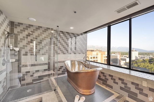 44 W Broadway S Unit 2005S, Salt Lake City, UT 84101 - bathroom featuring a freestanding tub, a mountain view, a stall shower, tile walls, and recessed lighting