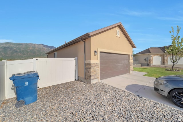 633 Little Rock Dr, Santaquin, UT 84655 - view of side of property with a mountain view, stone siding, stucco siding, driveway, and a garage