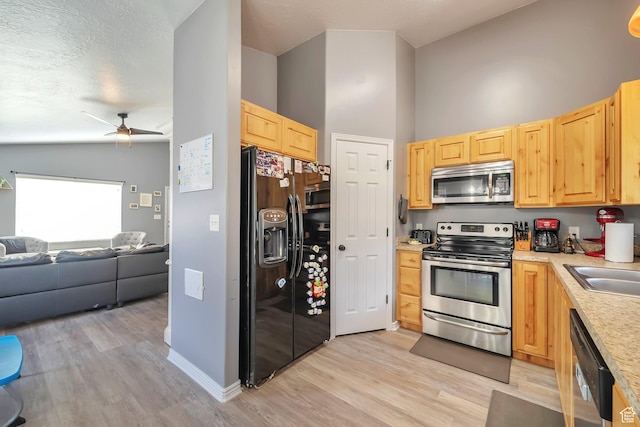 633 Little Rock Dr, Santaquin, UT 84655 - kitchen with appliances with stainless steel finishes, light brown cabinetry, open floor plan, light wood-type flooring, and light countertops