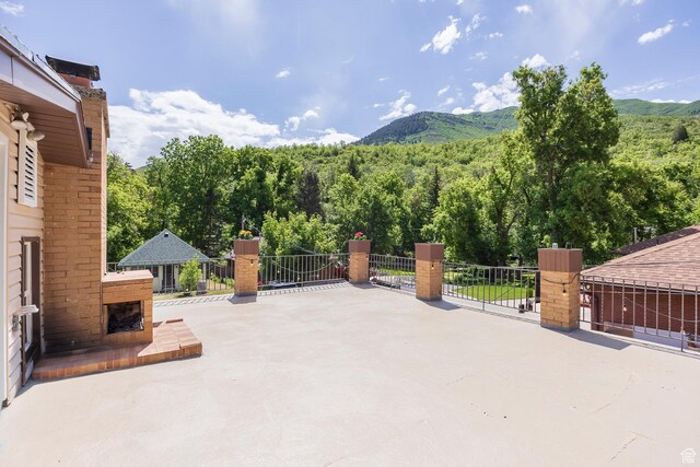 32 S Smokey Ln, Emigration Canyon, UT 84108 - view of patio / terrace with a mountain view, a wooded view, and a fireplace