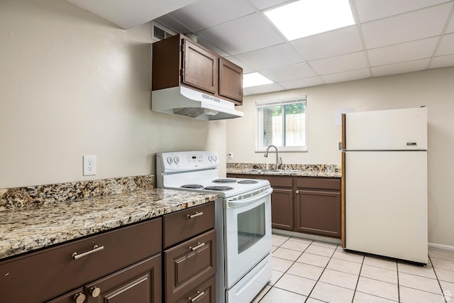32 S Smokey Ln, Emigration Canyon, UT 84108 - kitchen featuring white appliances, under cabinet range hood, dark brown cabinetry, light tile patterned floors, and light stone countertops