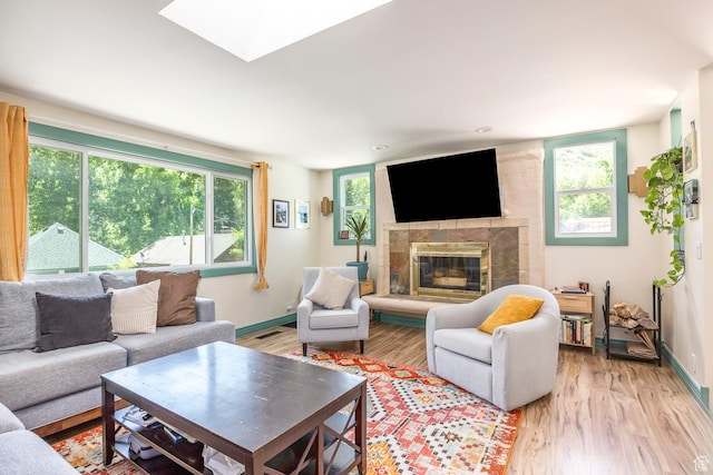 32 S Smokey Ln, Emigration Canyon, UT 84108 - living room featuring plenty of natural light, a glass covered fireplace, light wood-style flooring, and a skylight