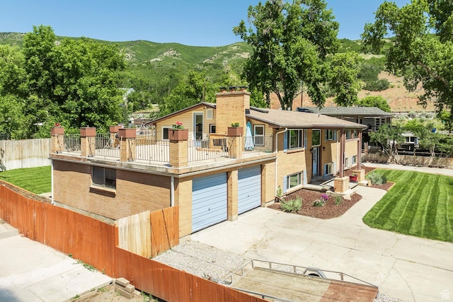 32 S Smokey Ln, Emigration Canyon, UT 84108 - view of front of property with a balcony, an attached garage, a chimney, a mountain view, and concrete driveway