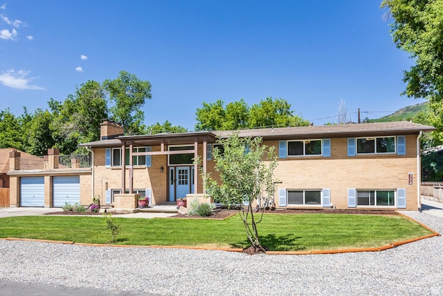 32 S Smokey Ln, Emigration Canyon, UT 84108 - view of front of home with a front lawn, a chimney, brick siding, and a garage