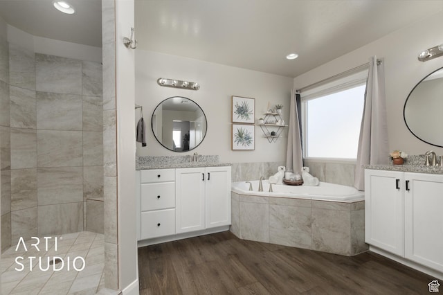 3694 E Tauri Way, St George, UT 84790 - full bath featuring wood finished floors, a bath, two vanities, a tile shower, and recessed lighting