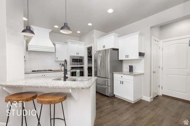 3694 E Tauri Way, St George, UT 84790 - kitchen featuring appliances with stainless steel finishes, premium range hood, dark wood-style floors, white cabinetry, and decorative backsplash