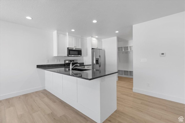 210 W 815 N Unit 24, Nephi, UT 84648 - kitchen with appliances with stainless steel finishes, a peninsula, light wood finished floors, recessed lighting, and white cabinets