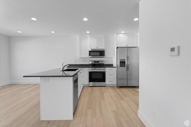 210 W 815 N Unit 24, Nephi, UT 84648 - kitchen with appliances with stainless steel finishes, a peninsula, recessed lighting, white cabinets, and light wood-style flooring