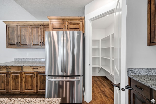 824 N 980 W, Tremonton, UT 84337 - kitchen with freestanding refrigerator, dark wood-style flooring, light stone countertops, and a textured ceiling