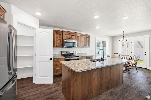 824 N 980 W, Tremonton, UT 84337 - kitchen featuring appliances with stainless steel finishes, dark wood-type flooring, a chandelier, light stone countertops, and a textured ceiling