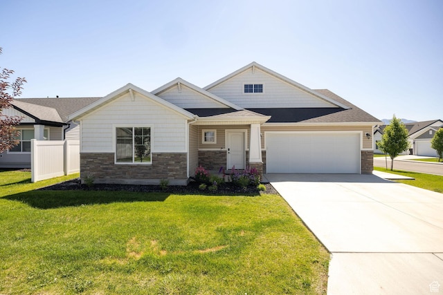 824 N 980 W, Tremonton, UT 84337 - craftsman-style home with stone siding, a garage, driveway, a front lawn, and roof with shingles