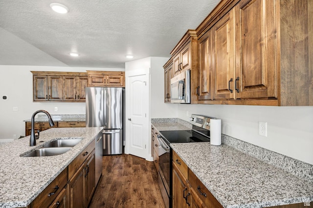 824 N 980 W, Tremonton, UT 84337 - kitchen with appliances with stainless steel finishes, dark wood-style flooring, a textured ceiling, brown cabinetry, and recessed lighting