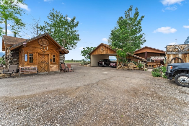 1665 E 1200 N, Mount Pleasant, UT 84647 - view of front facade featuring a detached carport, dirt driveway, and log exterior