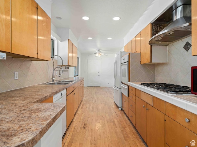 2713 N 650 E, North Ogden, UT 84414 - kitchen with wall chimney exhaust hood, white appliances, a ceiling fan, light wood-style flooring, and decorative backsplash