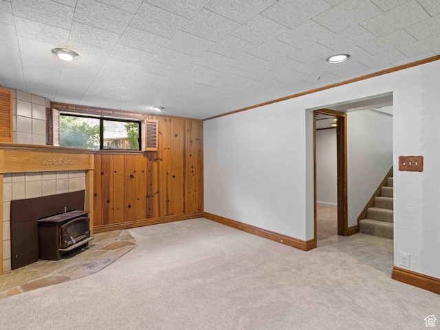 2713 N 650 E, North Ogden, UT 84414 - unfurnished living room featuring a wood stove, carpet floors, stairway, wooden walls, and crown molding