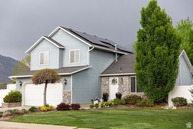 211 S 860 E, Orem, UT 84097 - traditional-style home with stone siding, roof mounted solar panels, an attached garage, a mountain view, and concrete driveway