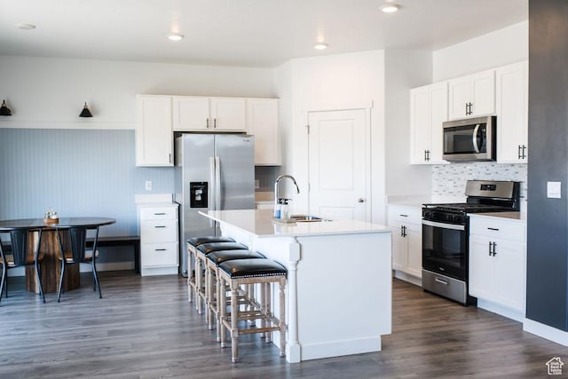 3657 E 1500 S, Spanish Fork, UT 84660 - kitchen featuring appliances with stainless steel finishes, a kitchen breakfast bar, a center island with sink, light countertops, and dark wood finished floors