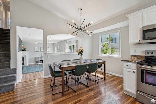 4052 W Newland Loop, Lehi, UT 84043 - dining area with stairway, dark wood-type flooring, a chandelier, and vaulted ceiling