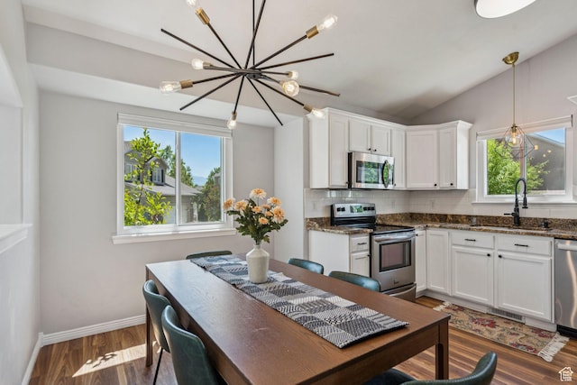 4052 W Newland Loop, Lehi, UT 84043 - kitchen with stainless steel appliances, a chandelier, backsplash, wood finished floors, and white cabinetry
