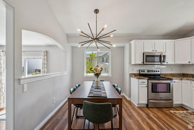 4052 W Newland Loop, Lehi, UT 84043 - kitchen with stainless steel appliances, a chandelier, white cabinets, backsplash, and lofted ceiling