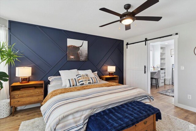 4124 S 3475 W, West Haven, UT 84401 - bedroom featuring a barn door, wood finished floors, ceiling fan, and a decorative wall