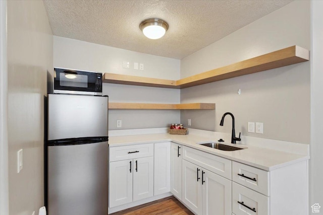4124 S 3475 W, West Haven, UT 84401 - kitchen with freestanding refrigerator, open shelves, a textured ceiling, white cabinetry, and light countertops