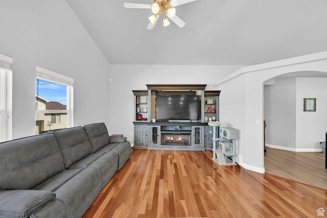 4317 S 3350 W, West Haven, UT 84401 - living room featuring arched walkways, a ceiling fan, wood finished floors, lofted ceiling, and a glass covered fireplace