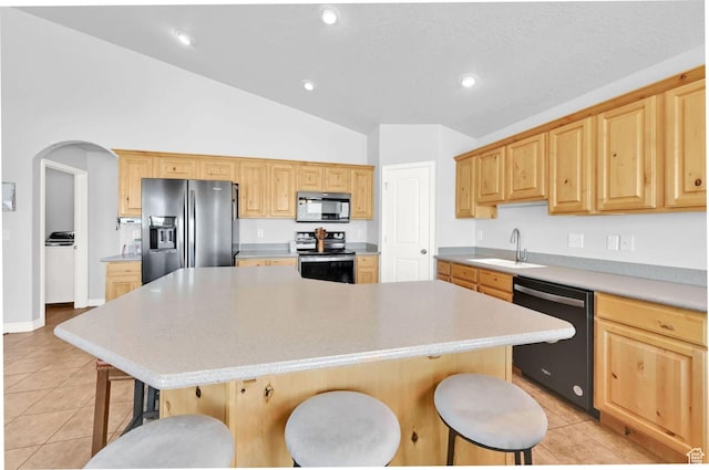 4317 S 3350 W, West Haven, UT 84401 - kitchen with stainless steel appliances, lofted ceiling, light tile patterned flooring, a breakfast bar area, and a kitchen island