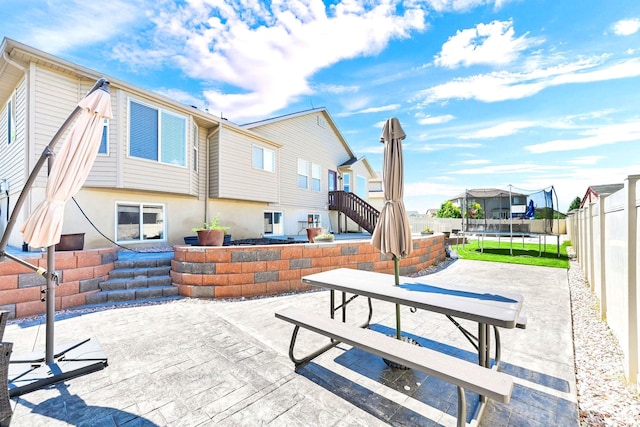 4317 S 3350 W, West Haven, UT 84401 - back of property featuring a trampoline, a patio, a fenced backyard, and a residential view
