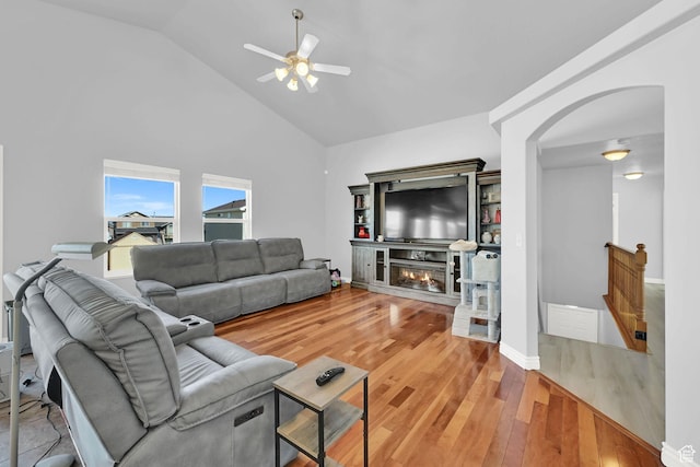 4317 S 3350 W, West Haven, UT 84401 - living room featuring ceiling fan, arched walkways, high vaulted ceiling, light wood-type flooring, and a glass covered fireplace