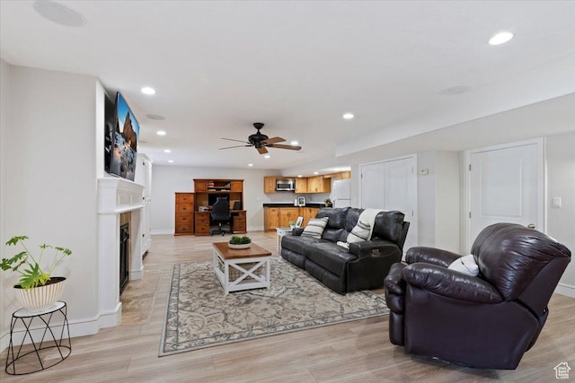 14257 S Round Rock Dr W, Herriman, UT 84096 - living room with recessed lighting, a desk, light wood finished floors, a fireplace with flush hearth, and ceiling fan