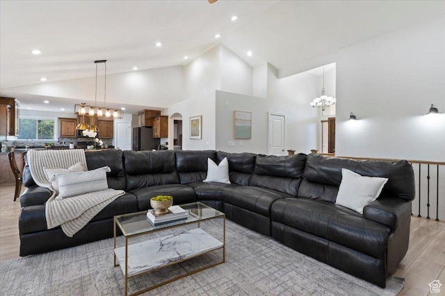 14257 S Round Rock Dr W, Herriman, UT 84096 - living area with a chandelier, arched walkways, light wood-style flooring, recessed lighting, and high vaulted ceiling