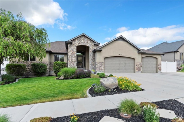 14257 S Round Rock Dr W, Herriman, UT 84096 - view of front of home with stone siding, an attached garage, stucco siding, and concrete driveway