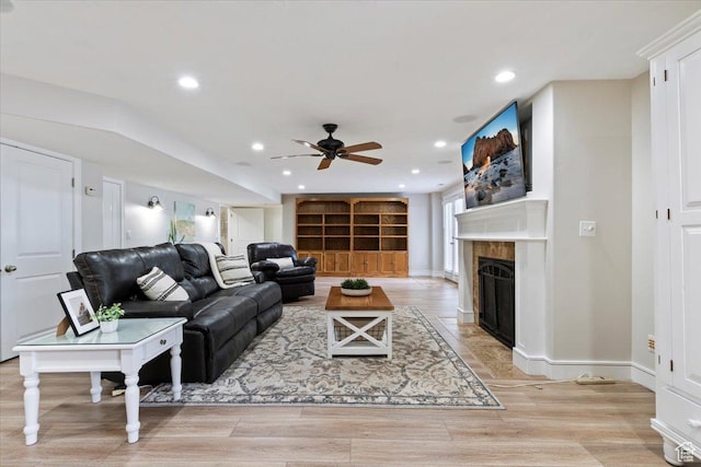 14257 S Round Rock Dr W, Herriman, UT 84096 - living area featuring a fireplace with flush hearth, a ceiling fan, recessed lighting, and light wood-style flooring