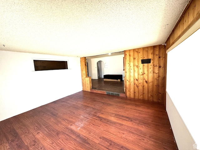 240 E 300 S, Kamas, UT 84036 - unfurnished room featuring arched walkways, wood finished floors, a textured ceiling, and wooden walls