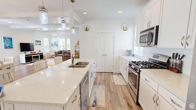 10612 S Lake Ave, South Jordan, UT 84009 - kitchen featuring stainless steel appliances, light wood finished floors, an island with sink, white cabinets, and recessed lighting