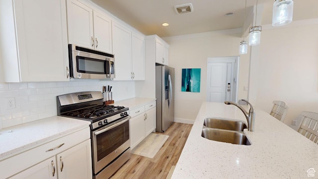10612 S Lake Ave, South Jordan, UT 84009 - kitchen featuring appliances with stainless steel finishes, white cabinetry, backsplash, light wood-style flooring, and pendant lighting