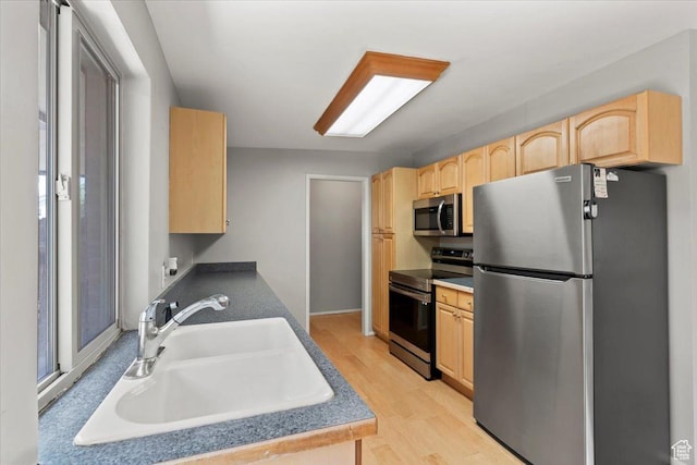 3705 W 3800 S, West Valley City, UT 84120 - kitchen featuring appliances with stainless steel finishes, light brown cabinets, light wood-style floors, and dark countertops