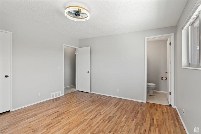 3705 W 3800 S, West Valley City, UT 84120 - unfurnished bedroom featuring light wood-type flooring, ensuite bath, and a textured ceiling