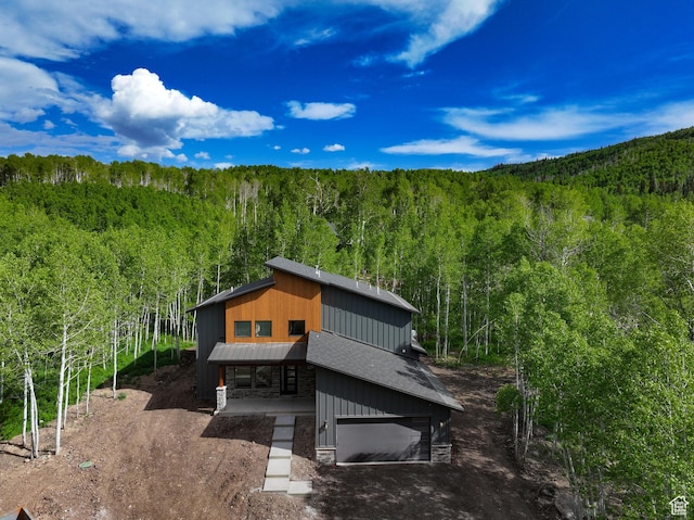 11234 E Columbine Ln, Heber City, UT 84032 - exterior space featuring a wooded view, stone siding, a garage, and dirt driveway
