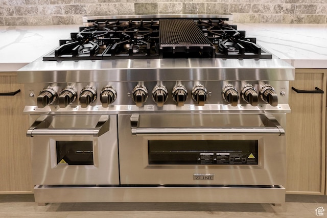 11234 E Columbine Ln, Heber City, UT 84032 - detailed view of range with two ovens, backsplash, and light stone countertops